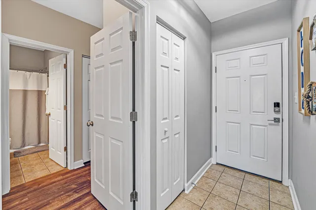 a view of a hallway with wooden floor and a bathroom