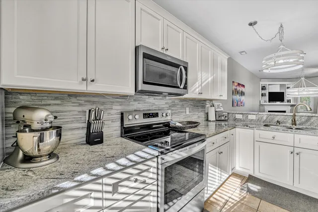 a kitchen with stainless steel appliances granite countertop a sink stove and cabinets