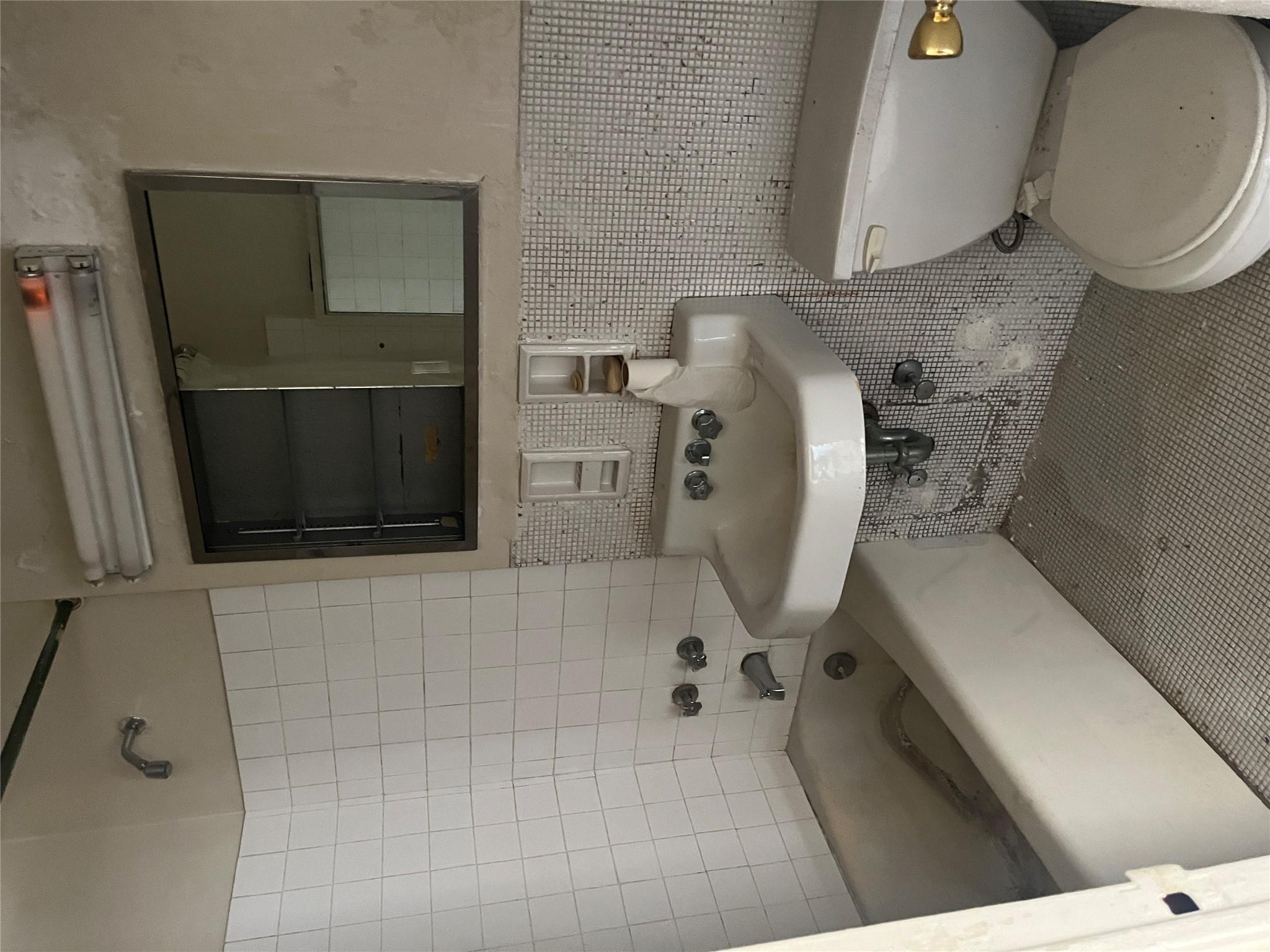1020 Grand Concourse, Unit 23T Bronx, NY 10451 - Photo 7 of 13 Full bathroom featuring tile patterned floors, tiled shower / bath combo, sink, tile walls, and toilet