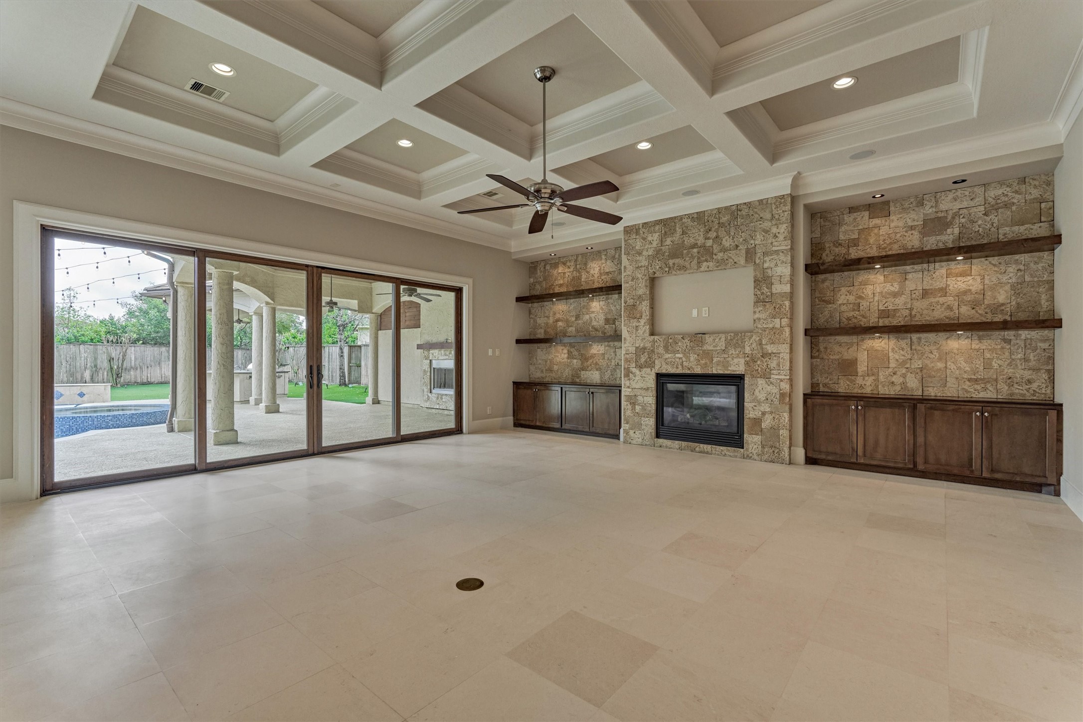 25 Post Shadow Estate Drive Spring, TX 77389 - Photo 17 of 49 Stunning great room with coffered ceiling, stone fireplace, built-ins, and expansive sliding glass doors.