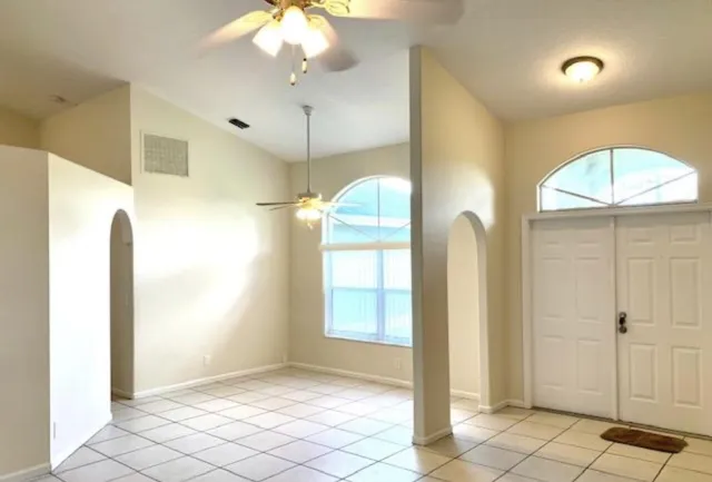 a view of a big room with a chandelier fan and windows