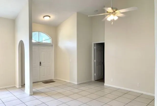 an empty room with closet and a chandelier fan