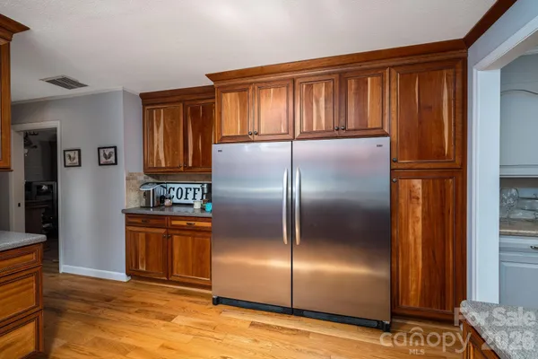a kitchen with stainless steel appliances granite countertop a sink dishwasher a stove a refrigerator with a dining table and chairs