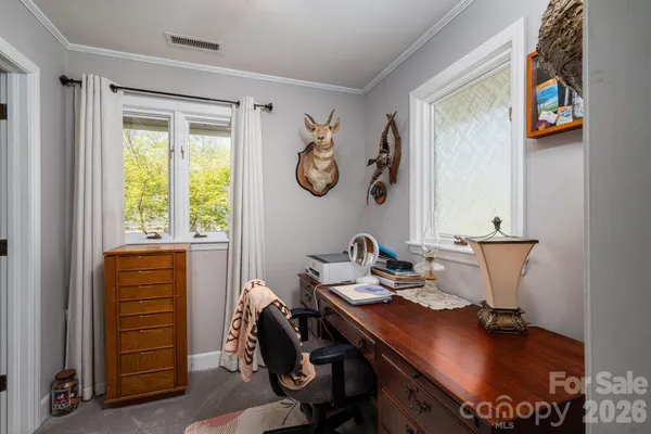 a bedroom with a bed and a flat tv screen on the dresser
