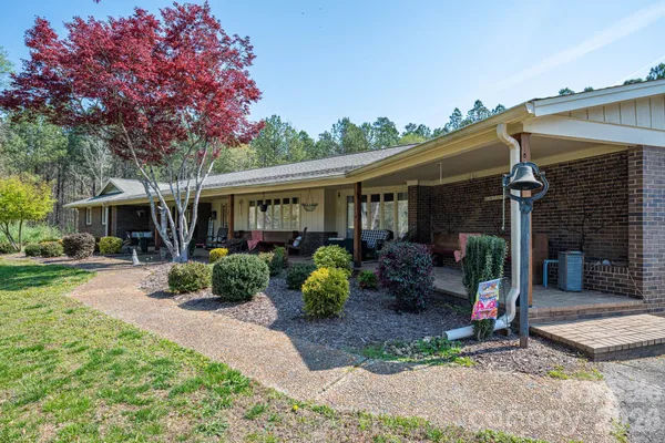 a view of a chair and table in backyard of the house