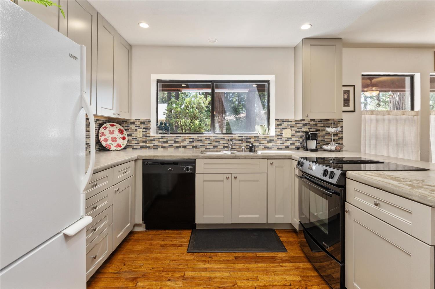 680 Larkspur Lane Murphys, CA 95247 - Photo 14 of 41 a kitchen with a stove a sink and a refrigerator