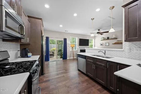 a kitchen with stainless steel appliances granite countertop a sink stove and refrigerator