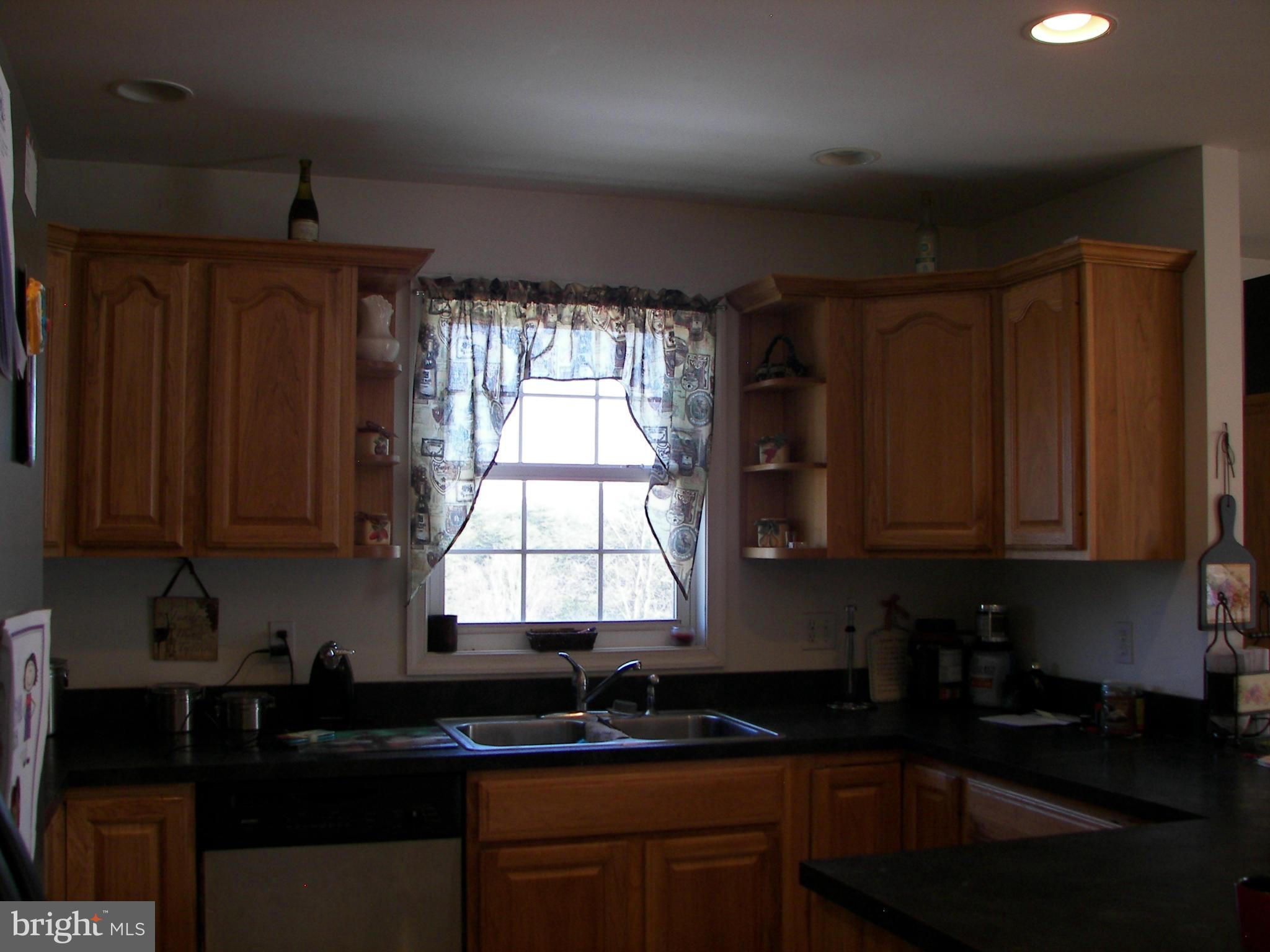 3619 Highland Ridge Road Berkeley Springs, WV 25411 - Photo 10 of 30 a kitchen with granite countertop a sink window and cabinets