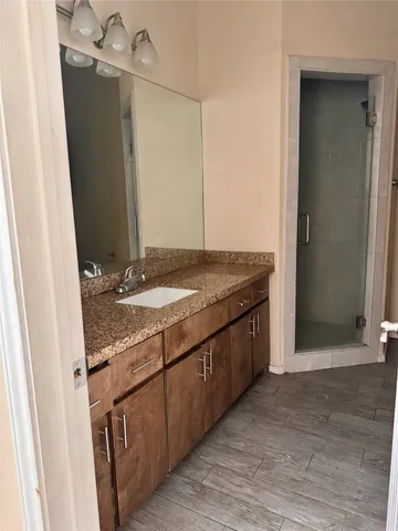 a bathroom with a granite countertop sink and a mirror
