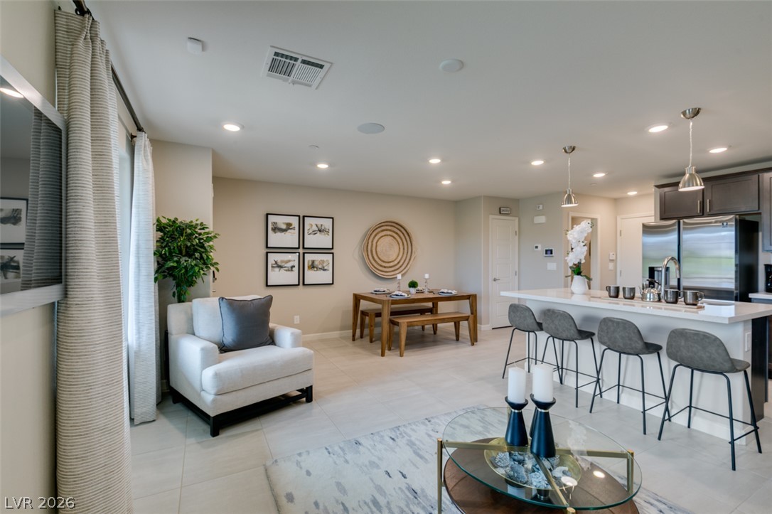 653 Pickled Pepper Place Henderson, NV 89011 - Photo 12 of 35 An open-concept living area seamlessly connects a modern kitchen, dining space, and inviting sitting area.