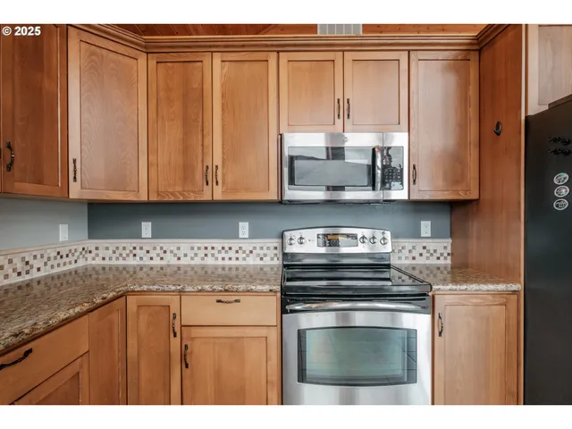 a kitchen with stainless steel appliances granite countertop a refrigerator and cabinets