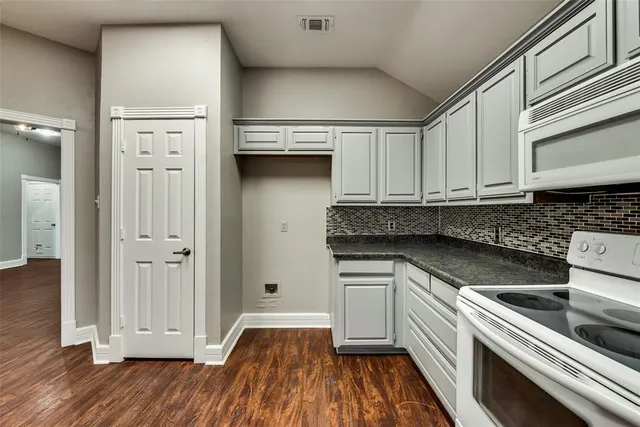 a kitchen with granite countertop a stove and a refrigerator