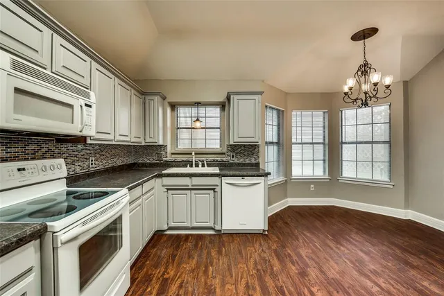 a kitchen with stainless steel appliances granite countertop wooden cabinets a stove a sink and dishwasher