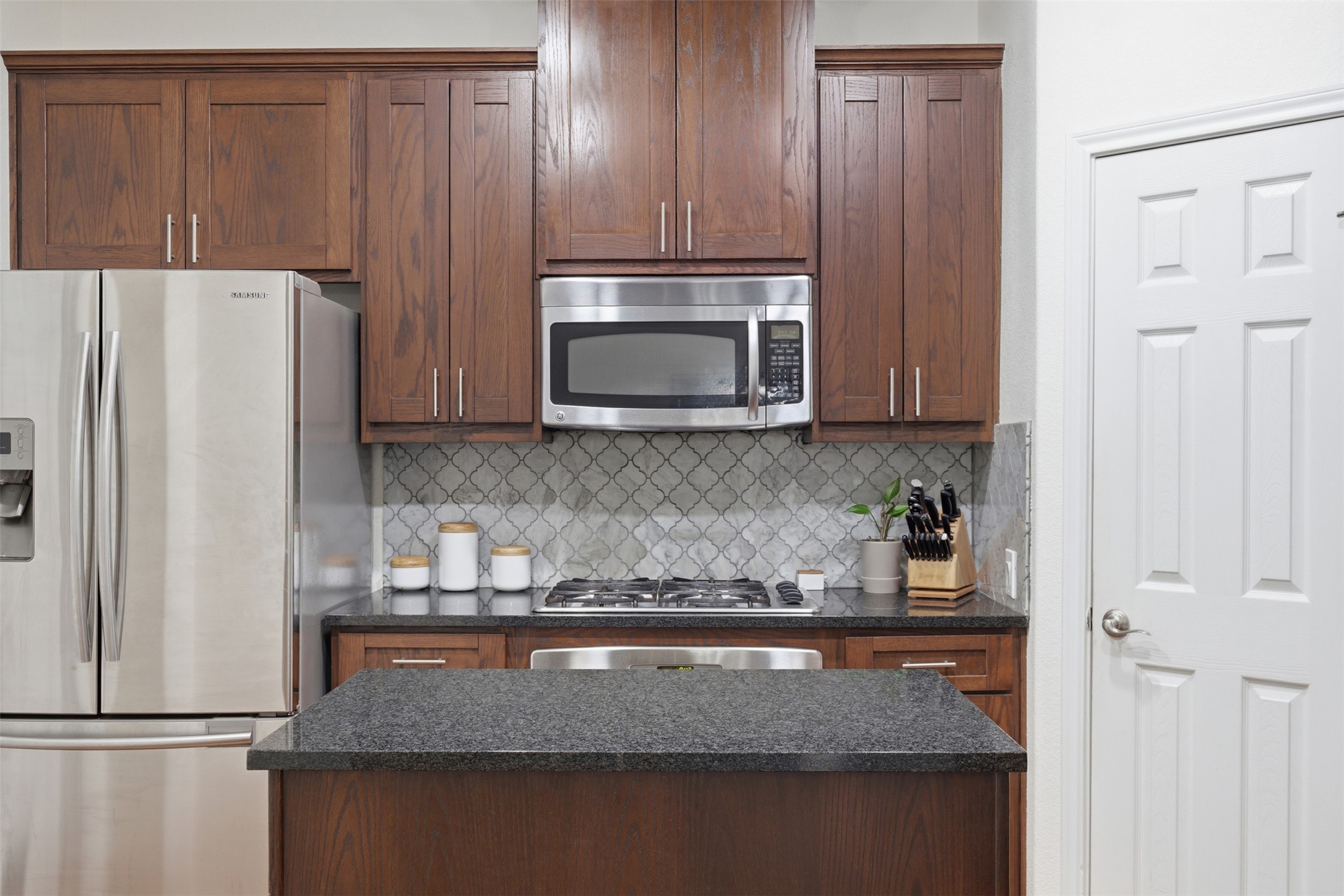 15331 Origins Lane Austin, TX 78734 - Photo 8 of 30 a kitchen with granite countertop a refrigerator stove and microwave