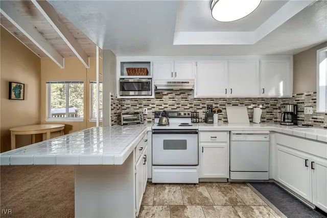 a kitchen with stainless steel appliances granite countertop a sink stove and cabinets