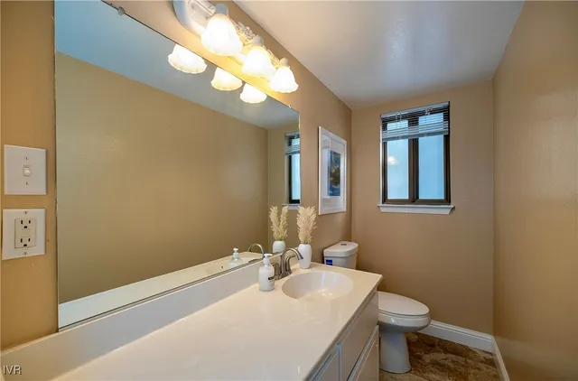 a bathroom with a toilet a sink and mirror