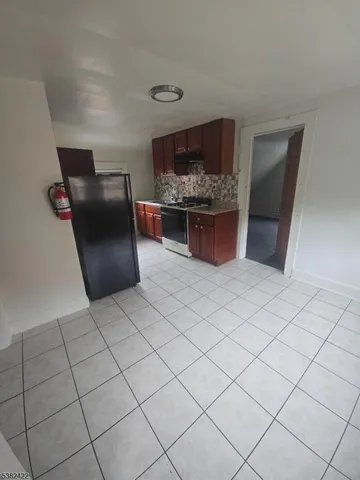 a kitchen with stainless steel appliances kitchen island granite countertop a refrigerator and a stove
