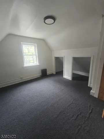 an empty room with a fireplace and windows