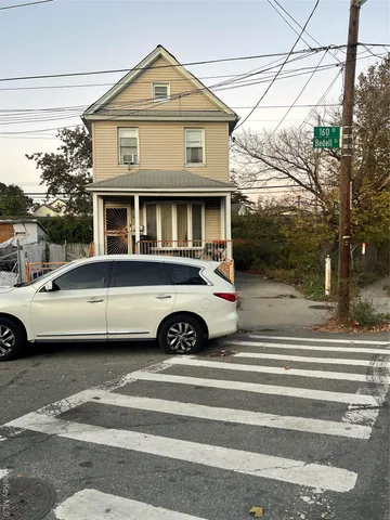 a front view of a house with a parking space