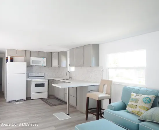 a kitchen with white cabinets appliances a sink and a window
