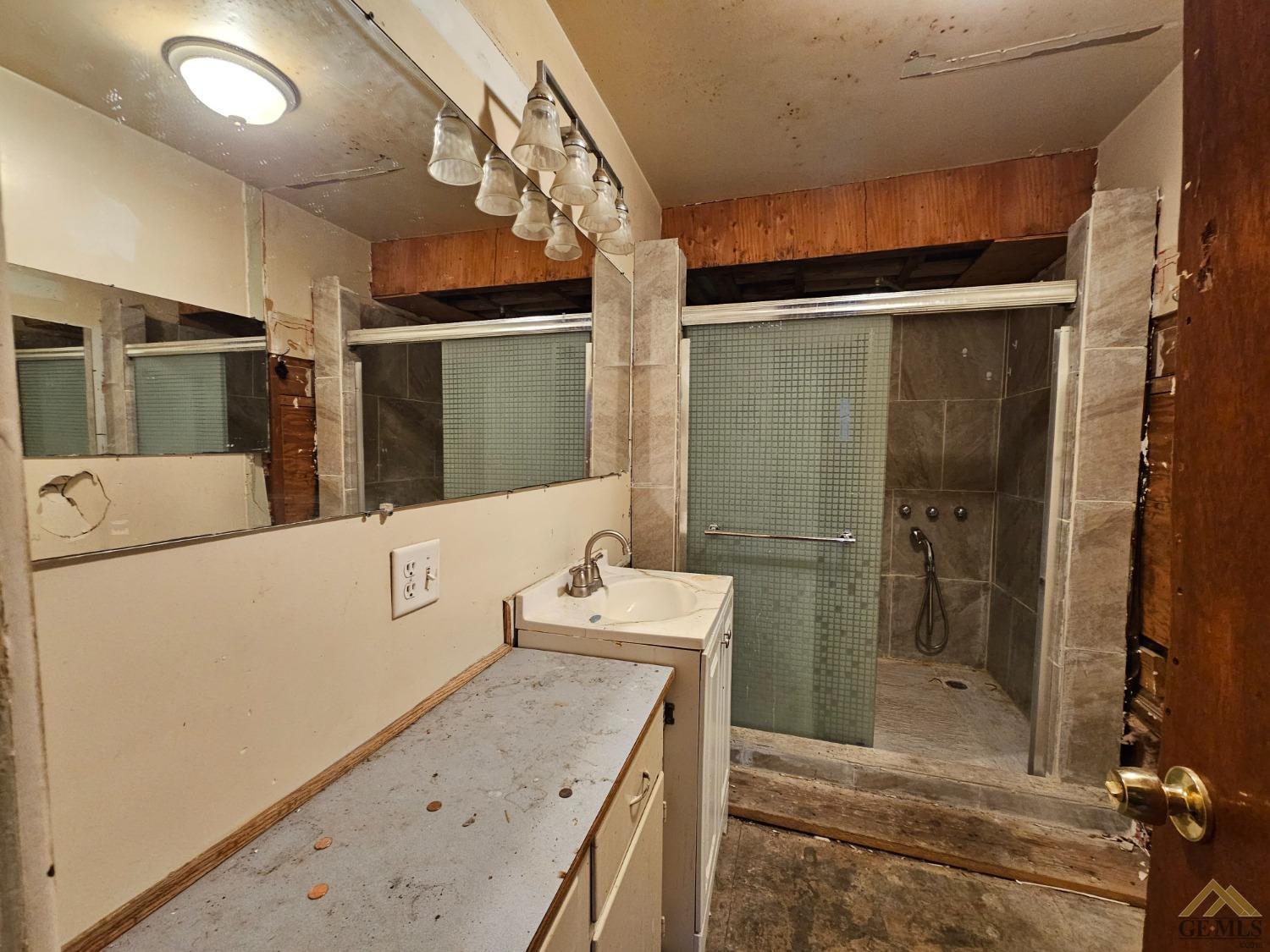 Undisclosed Address Taft, CA 93268 - Photo 12 of 20 a bathroom with a granite countertop sink a mirror and shower