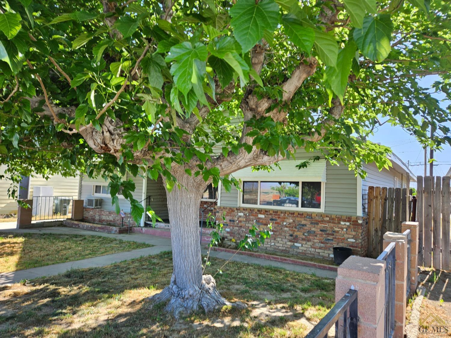 Undisclosed Address Taft, CA 93268 - Photo 2 of 20 a front view of house with yard and trees