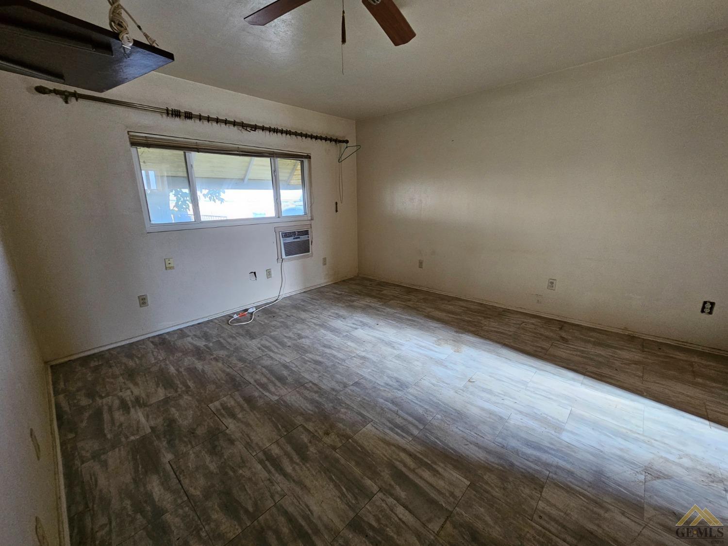 Undisclosed Address Taft, CA 93268 - Photo 10 of 20 an empty room with wooden floor cabinet and windows