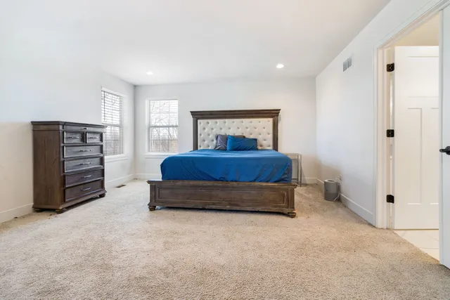 a spacious bedroom with a bed and a chandelier
