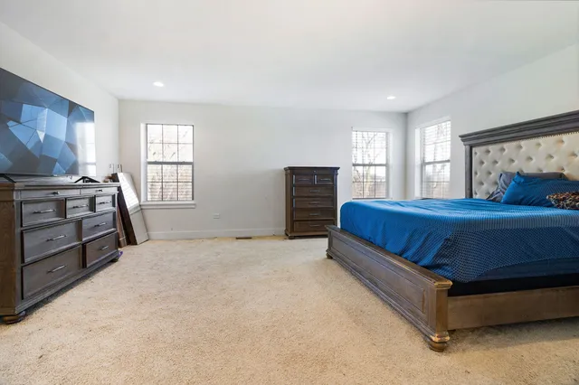 a bedroom with a bed and a flat tv screen on the dresser