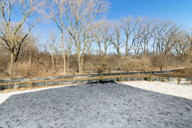 a view of a yard with wooden fence