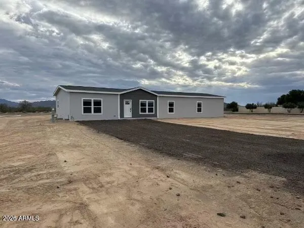 a view of house with yard and car parked in the background