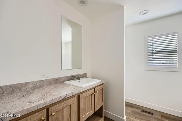 a bathroom with a granite countertop sink and a mirror