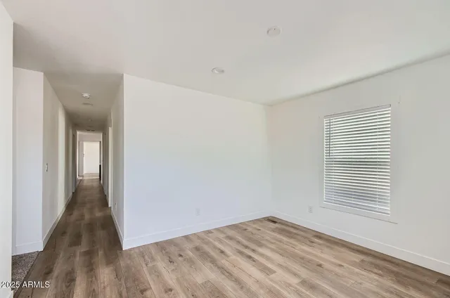 a view of a room with wooden floor and a window