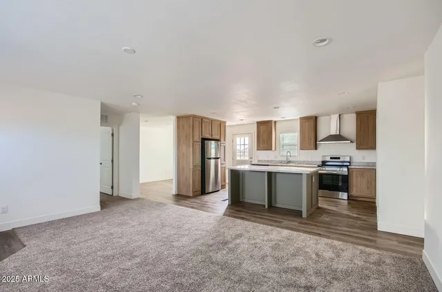 a large kitchen with a refrigerator and white cabinets