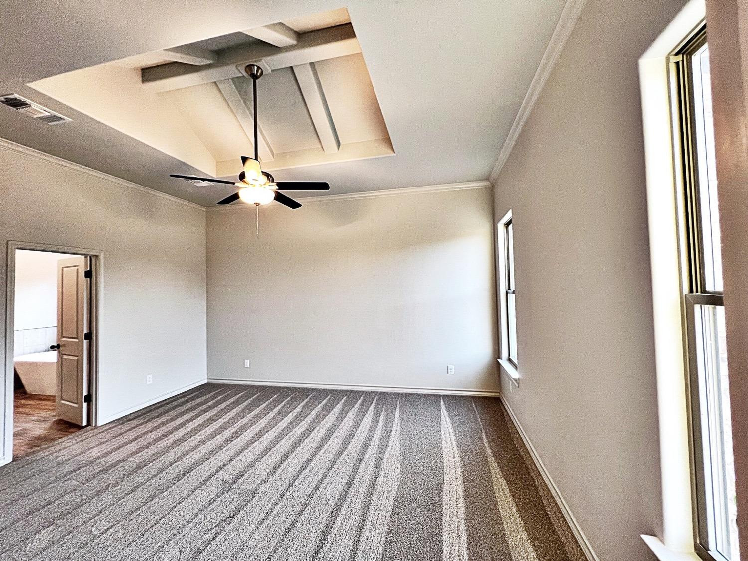 6920 17th Street Lubbock, TX 79416 - Photo 16 of 34 an empty room with wooden floor fan and windows