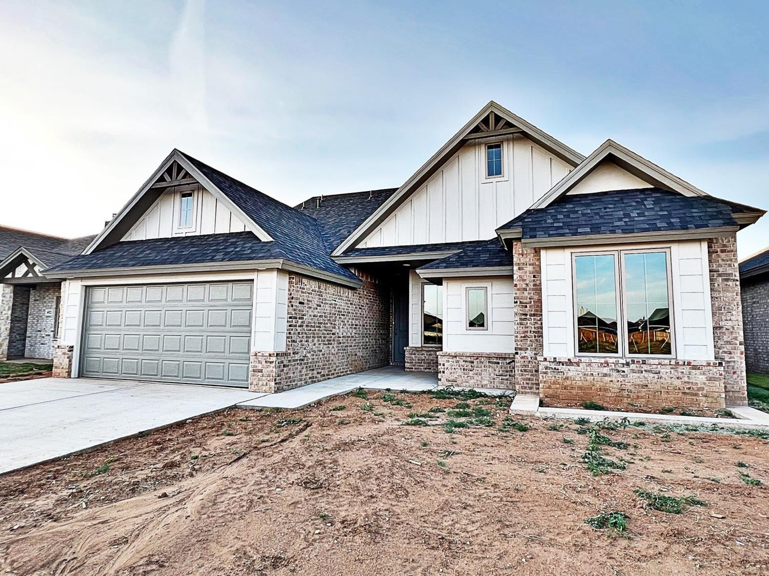6920 17th Street Lubbock, TX 79416 - Photo 2 of 34 a front view of a house with a yard and garage