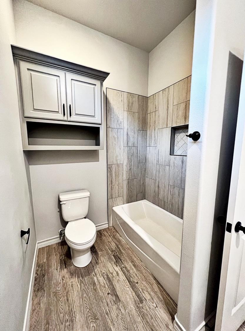 6920 17th Street Lubbock, TX 79416 - Photo 27 of 34 a bathroom with a toilet a sink and a bathtub