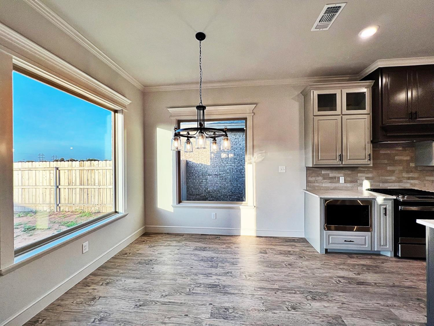 6920 17th Street Lubbock, TX 79416 - Photo 5 of 34 a view of an empty room with a kitchen and a window