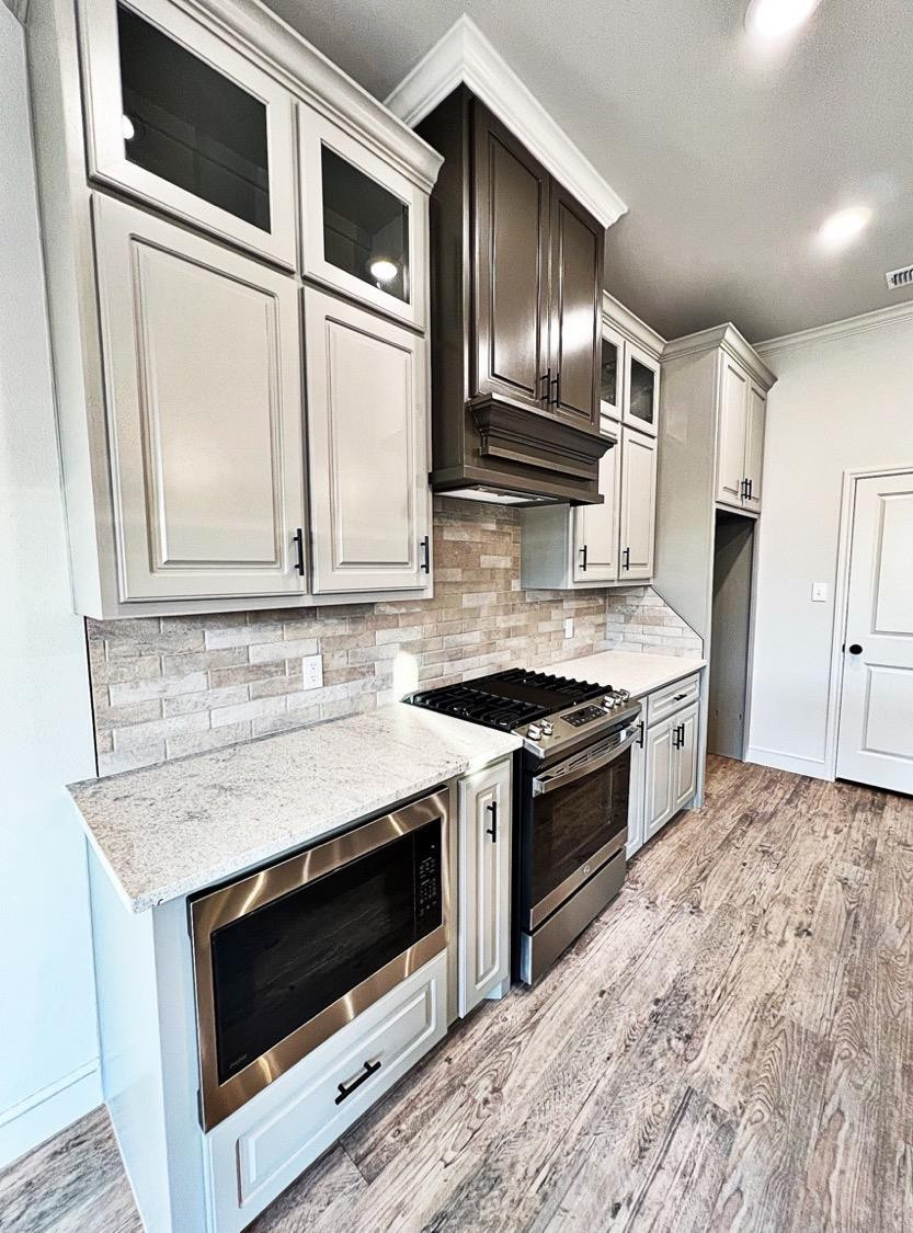 6920 17th Street Lubbock, TX 79416 - Photo 7 of 34 a kitchen with stainless steel appliances granite countertop a stove microwave and sink