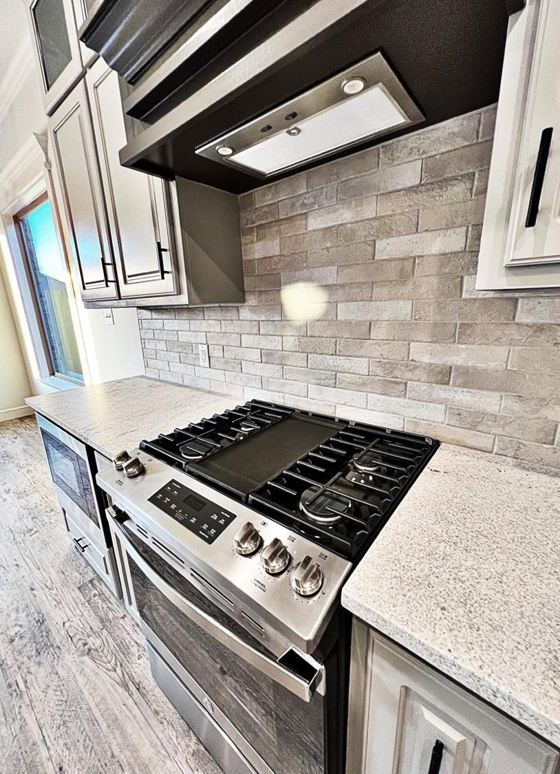 6920 17th Street Lubbock, TX 79416 - Photo 10 of 34 a stove top oven sitting inside of a kitchen