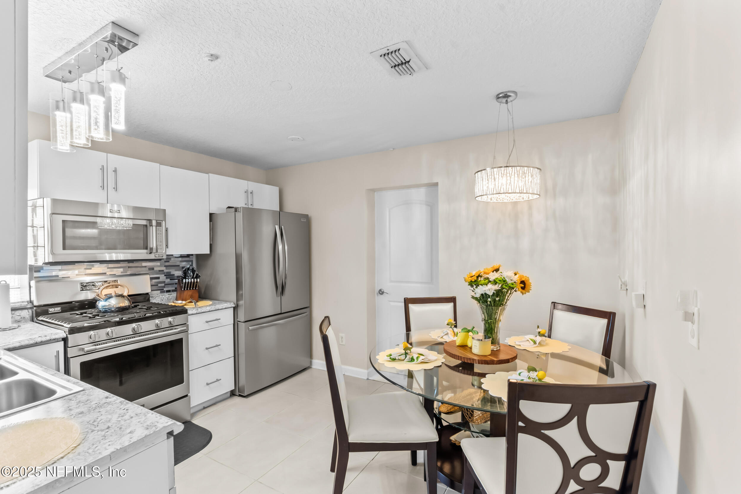 1887 Mayport Road Atlantic Beach, FL 32233 - Photo 14 of 50 a kitchen with stainless steel appliances kitchen island granite countertop a dining table and chairs