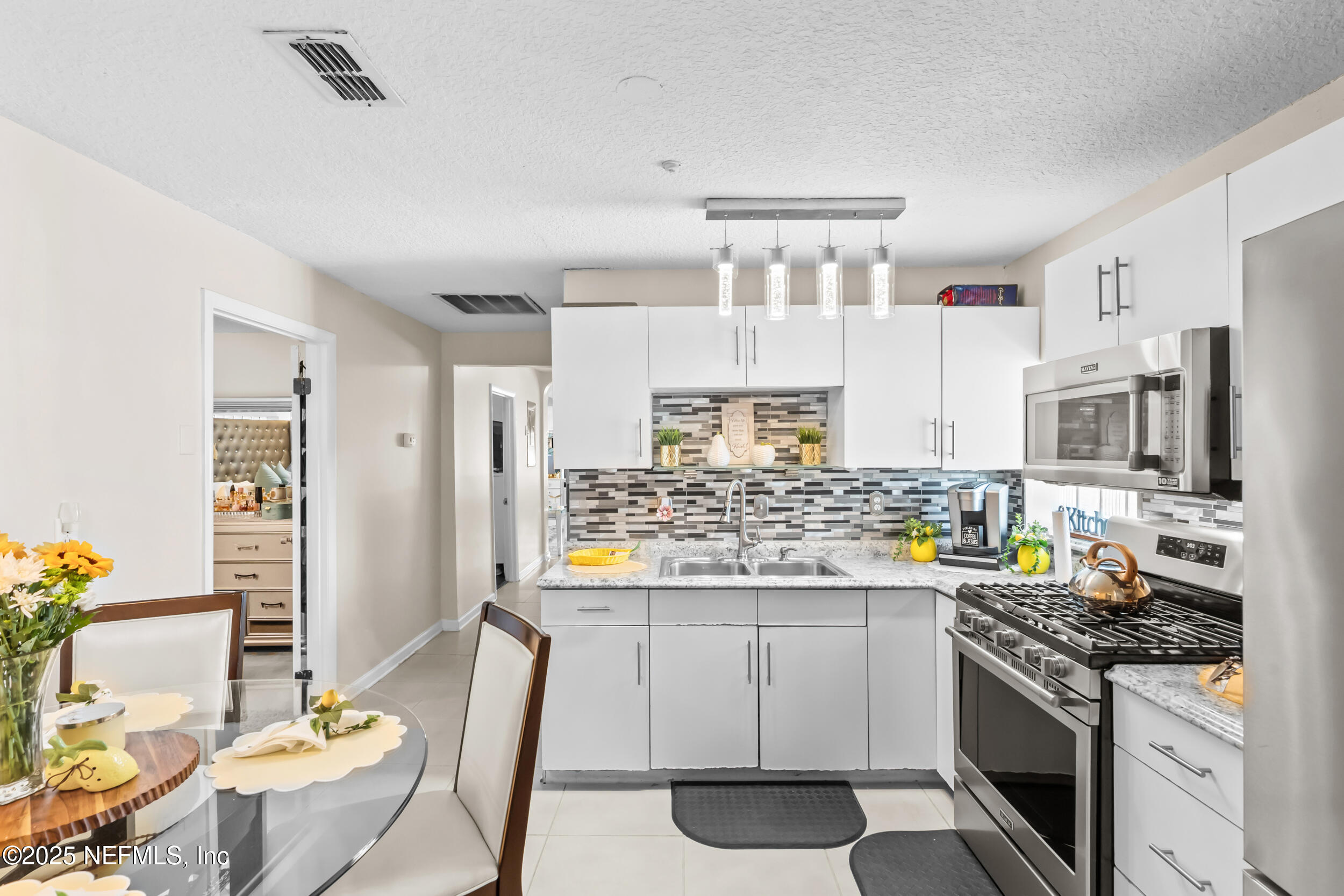 1887 Mayport Road Atlantic Beach, FL 32233 - Photo 16 of 50 a kitchen with stainless steel appliances a stove a sink dishwasher a refrigerator white cabinets and wooden floor
