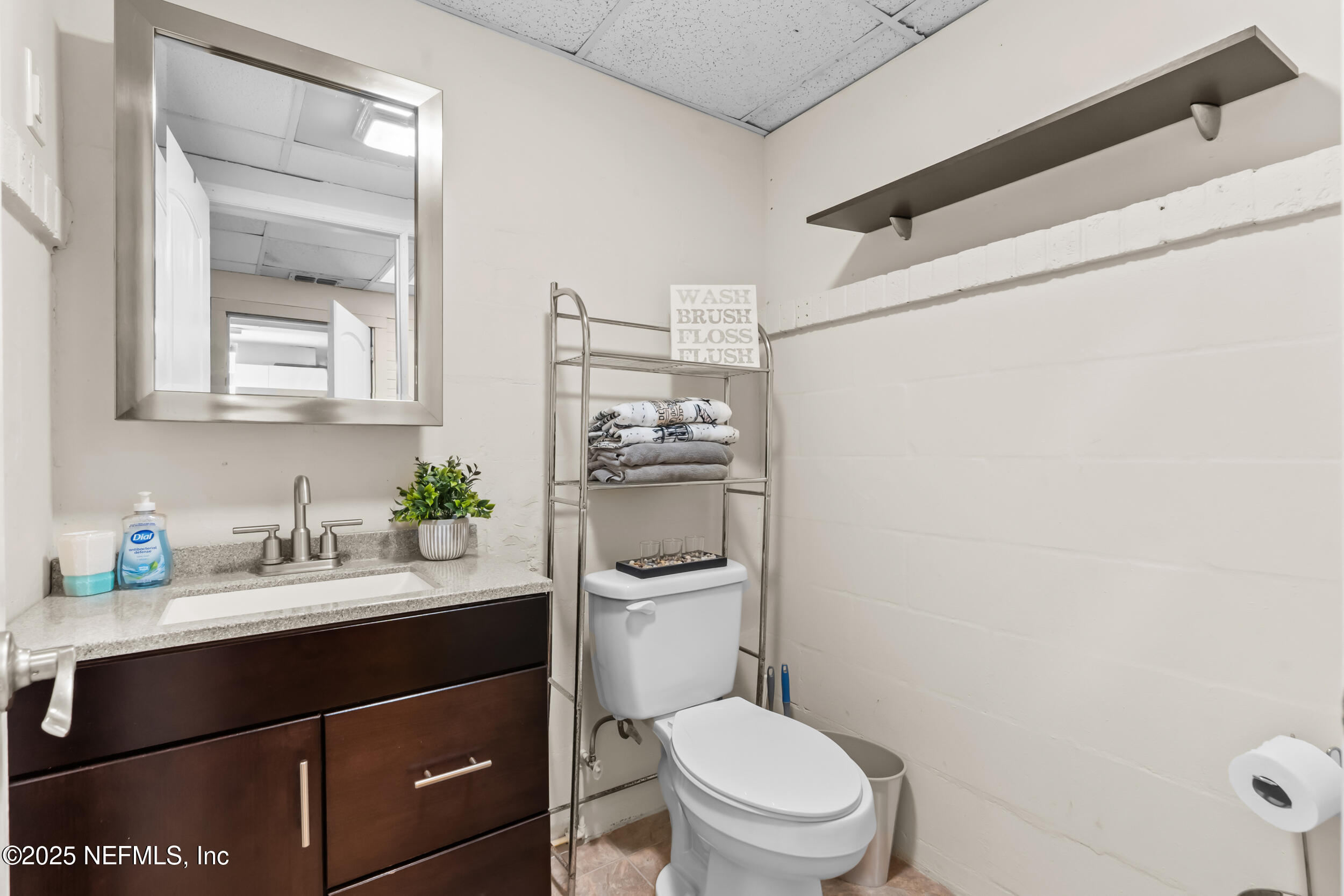 1887 Mayport Road Atlantic Beach, FL 32233 - Photo 25 of 50 a bathroom with a granite countertop toilet sink and mirror
