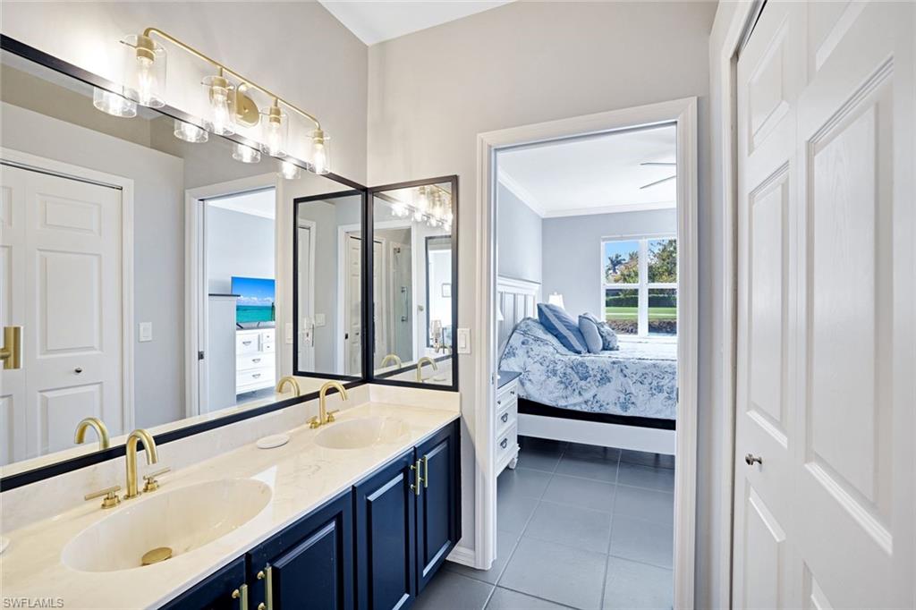 5967 Sand Wedge Lane, Unit 104 Naples, FL 34110 - Photo 13 of 41 a en suite bathroom with a granite countertop sink and a mirror