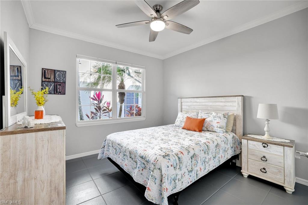 5967 Sand Wedge Lane, Unit 104 Naples, FL 34110 - Photo 14 of 41 a bedroom with a bed and a dresser