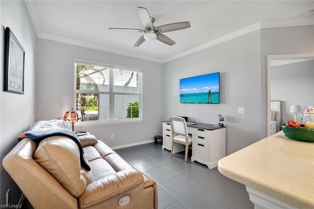 5967 Sand Wedge Lane, Unit 104 Naples, FL 34110 - Photo 16 of 41 a living room with furniture two window and a chandelier