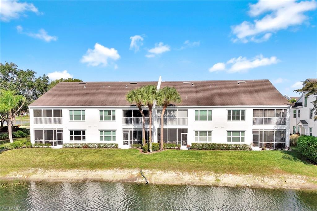5967 Sand Wedge Lane, Unit 104 Naples, FL 34110 - Photo 24 of 41 a front view of a house with a yard