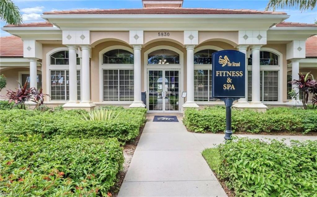 5967 Sand Wedge Lane, Unit 104 Naples, FL 34110 - Photo 35 of 41 a front view of brick house with potted plants