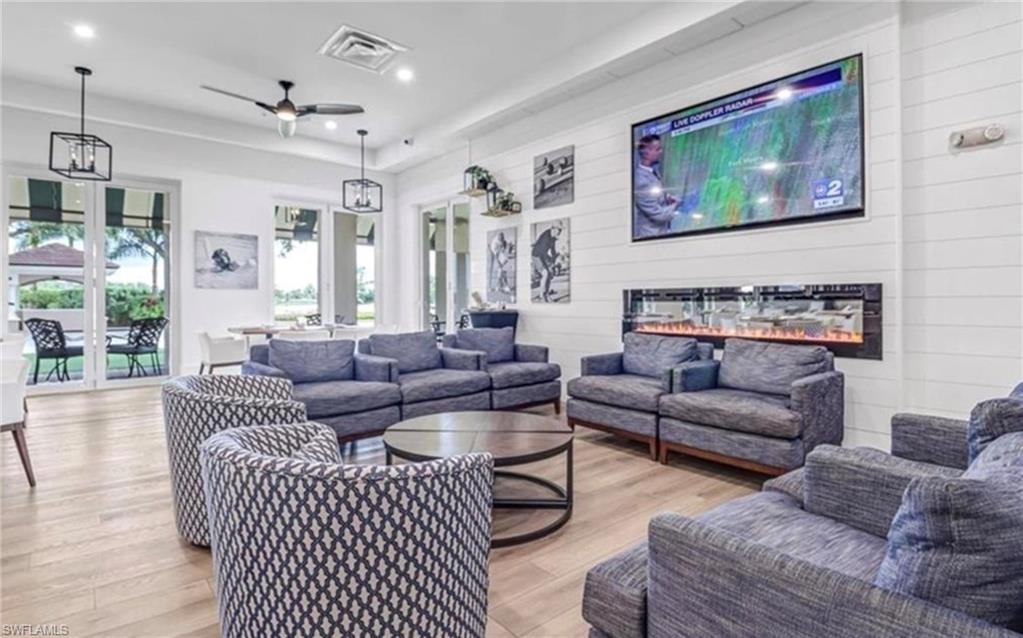 5967 Sand Wedge Lane, Unit 104 Naples, FL 34110 - Photo 40 of 41 a living room with furniture and a painting