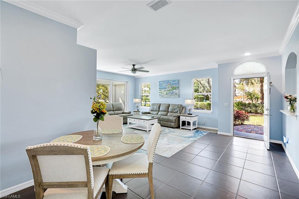 5967 Sand Wedge Lane, Unit 104 Naples, FL 34110 - Photo 9 of 41 a view of a dining room with furniture and a potted plant